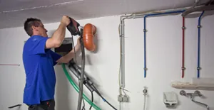 Elektriker verlegt Leitungen an der Wand
