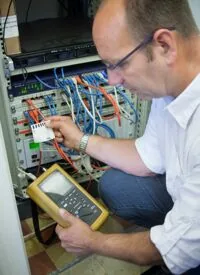 Altfried Reick misst an einem Netzwerkschrank