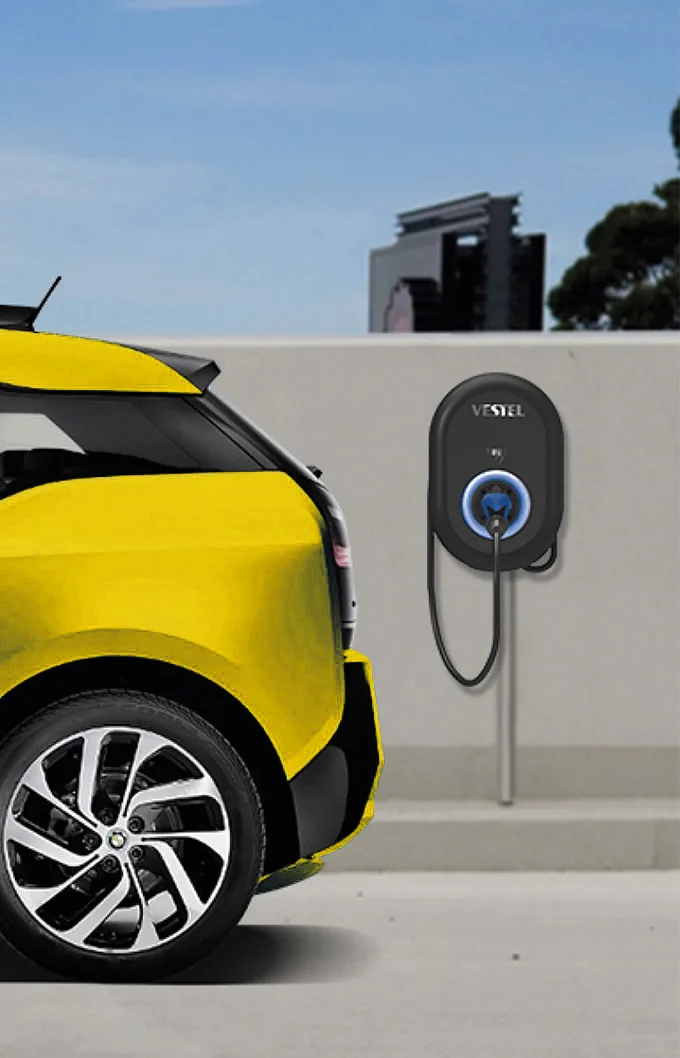 Wallbox an einer Hauswand neben einem gelben Elektroauto